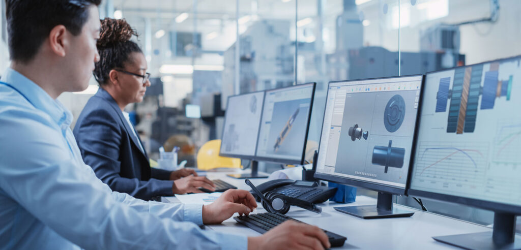 A photo of two people on their workstations designing devices